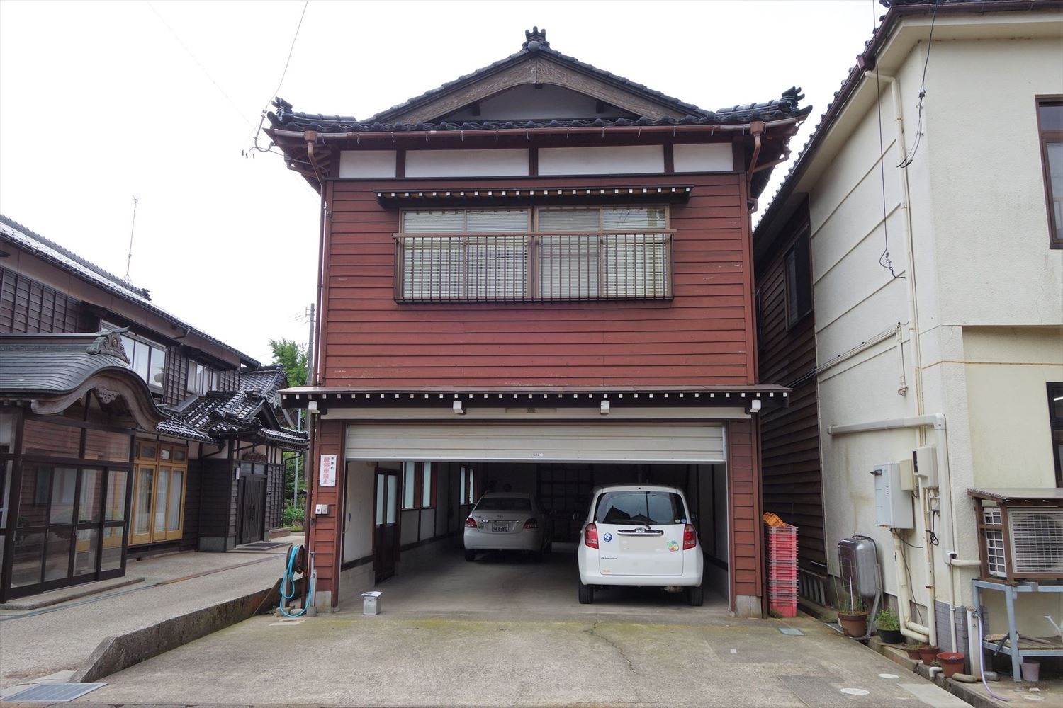 珠洲市正院町に立つ車庫付き住宅の23年奥能登地震後の状態。基礎とモルタル壁の室内側にひびが入った。モルタル壁の一部が脱落した（写真：建物修復支援ネットワーク）