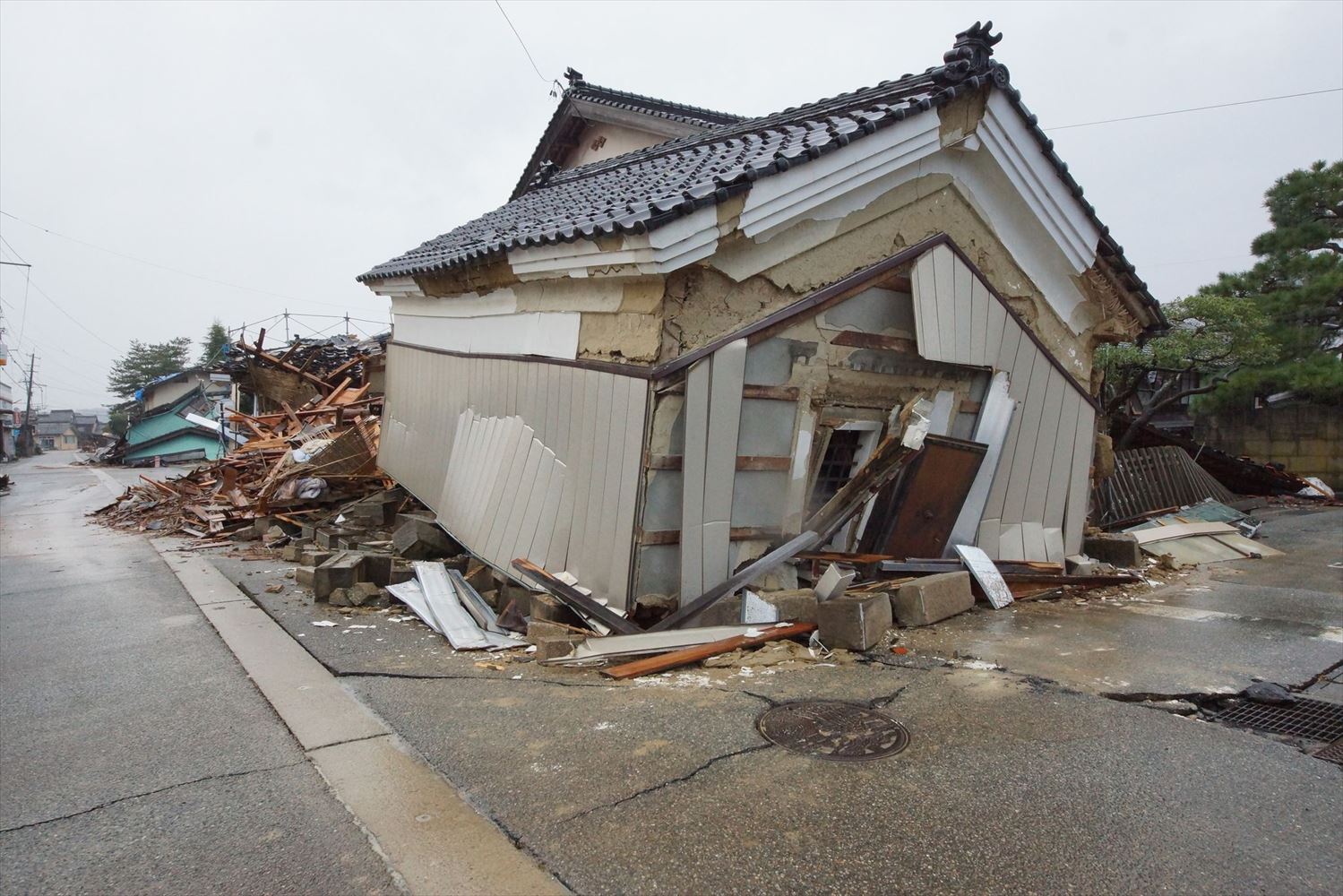 同住宅の24年能登半島地震後の状態。層崩壊した。越冬に向けて、屋根と外壁まわりの修復工事を先行させている矢先だった（写真：建物修復支援ネットワーク）