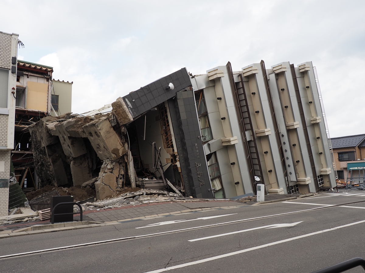 西側から見たビル転倒現場。ビルの東側が地面にめり込み、床側の地面が盛り上がっているように見える（写真：池谷 和浩）