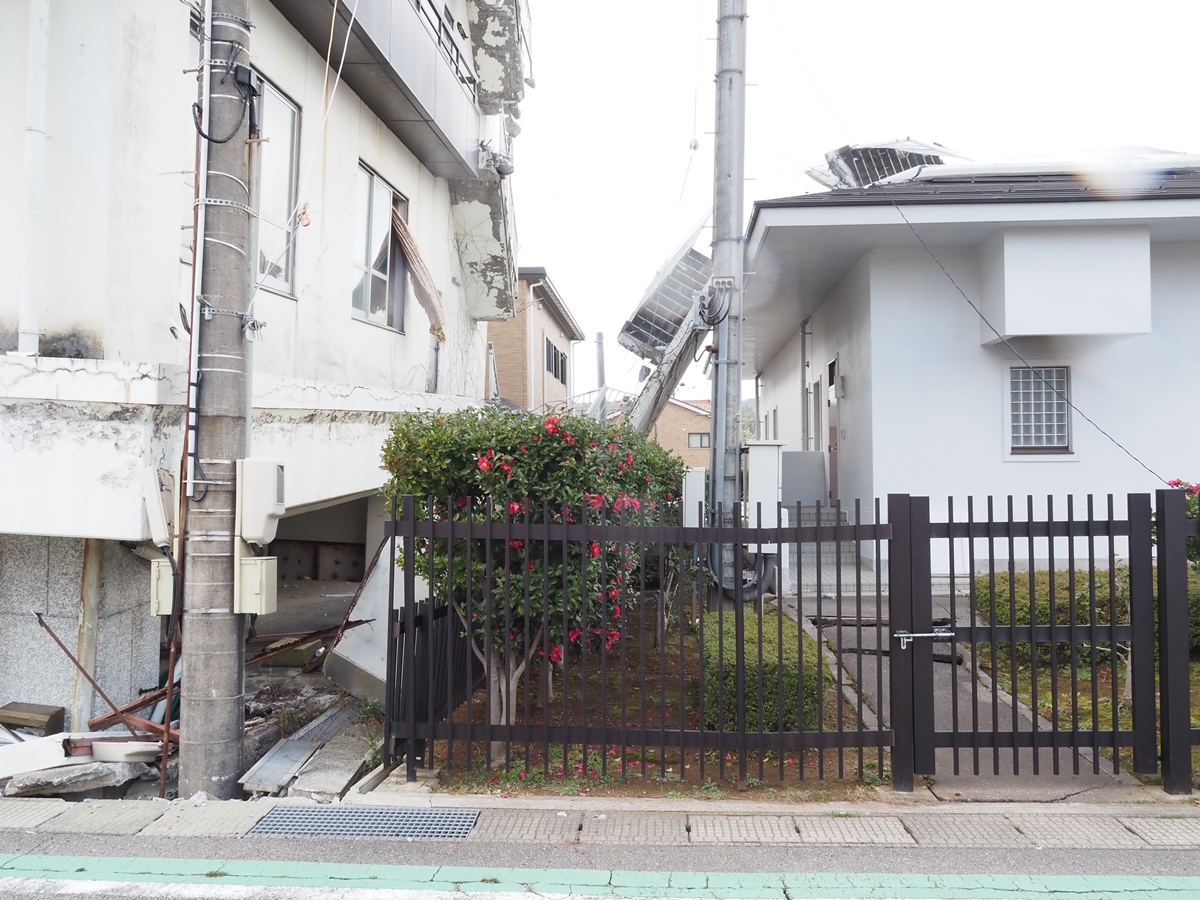 ビル北面にあった壁が階段ごと壊れ、隣に立つ建物の屋根に倒れ込んでいた（写真：日経クロステック）