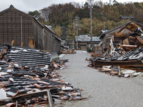 国道249号側から旧角海家住宅(写真左手)を見る。手前から奥に向かって米蔵、小豆蔵、塩物蔵、主屋が連なる。写真中央に見えるのが倒壊した主屋の一部。塩物蔵は大きく傾いている(写真:日経クロステック)