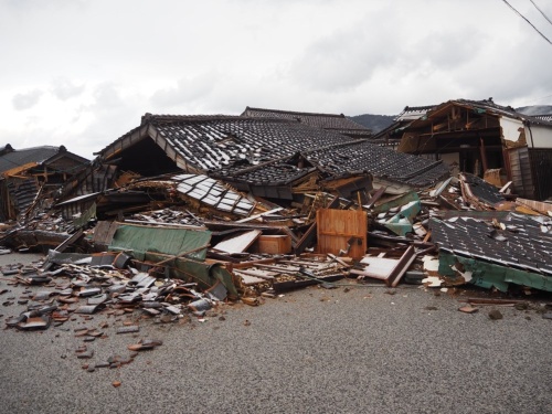 倒壊した主屋を南側から見る。写真右手奥に見える一部を残して崩れ落ちている。緑色のシートは屋根防水のためのアスファルトルーフィングと見られる(写真:日経クロステック)