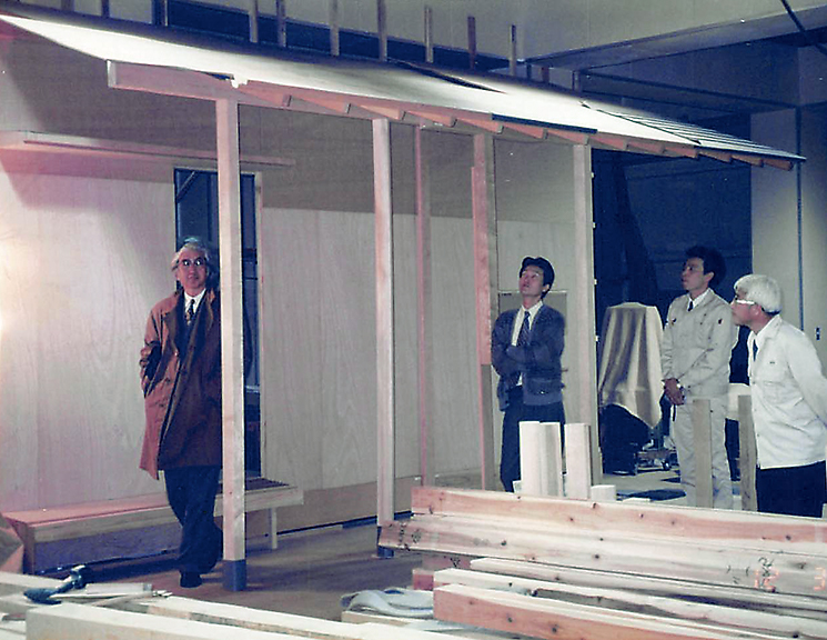 「松韻亭」の設計に当たり、水澤工務店は自社工場内に屋根の原寸模型を制作した。左は模型を確認する谷口（写真：水澤工務店）