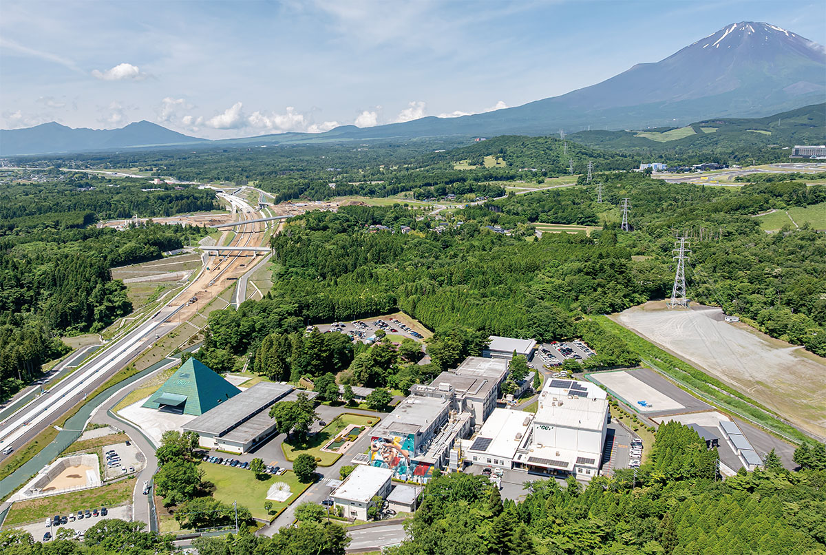 富士山麓で緑色に輝くピラミッド、新東名の脇に立つ坂茂氏設計の工場