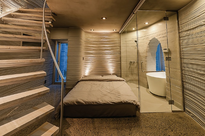 平面は渦巻き状に見える。キッチンやインテリアは樹脂でプリントした。住宅を発注した企業は地域おこしの一環として、3Dプリンター住宅に目を付けた。将来的には旅館業法に基づく許可を取得し、民泊のような使い方も想定している(写真:オノコム)