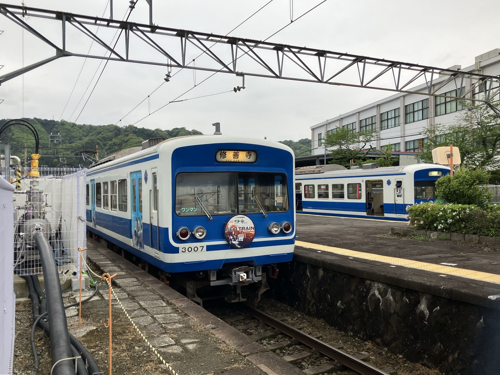 図1　伊豆箱根鉄道駿豆線で超電導送電の区間を設けた。黒色のケーブル（左下）が超電導ケーブル（出所：鉄道総合技術研究所）