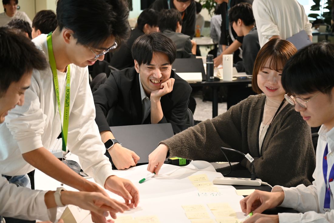 NECが2025年10月に実施した生成AIハッカソンの様子。100人の募集枠に160人以上が応募。選考を経て参加した100人の新入社員が20チームに分かれ、アプリを開発して競った