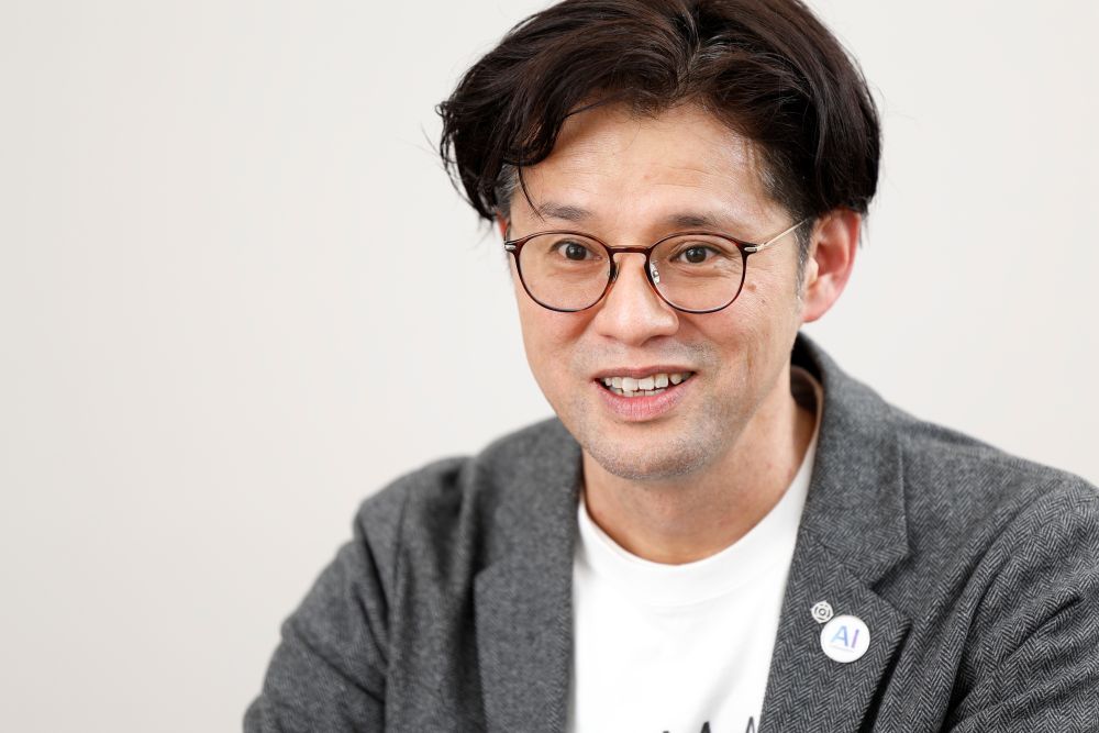 日立製作所の黒川氏は、人がAIエージェントやロボットと密接に連係する世界を目指す（写真：村田和聡）