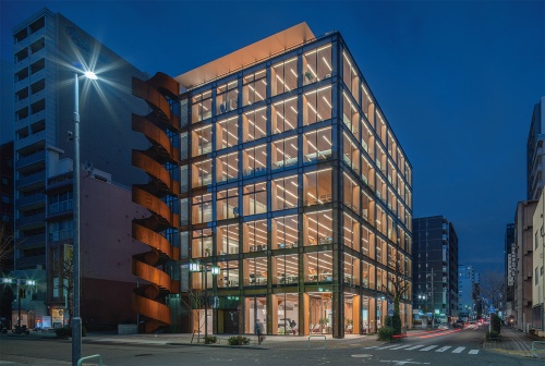 名古屋市中区丸の内2丁目に完成したオフィスビル「タマディック名古屋ビル」。夜になると、CLTで覆われた柱や天井が外からよく見える（写真：車田 保）