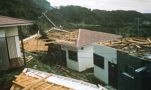 1975年台風13号による木造戸建て住宅の被害。台風で屋根が剥がされ、ひっくり返っている（写真左手前）（写真：筆者）