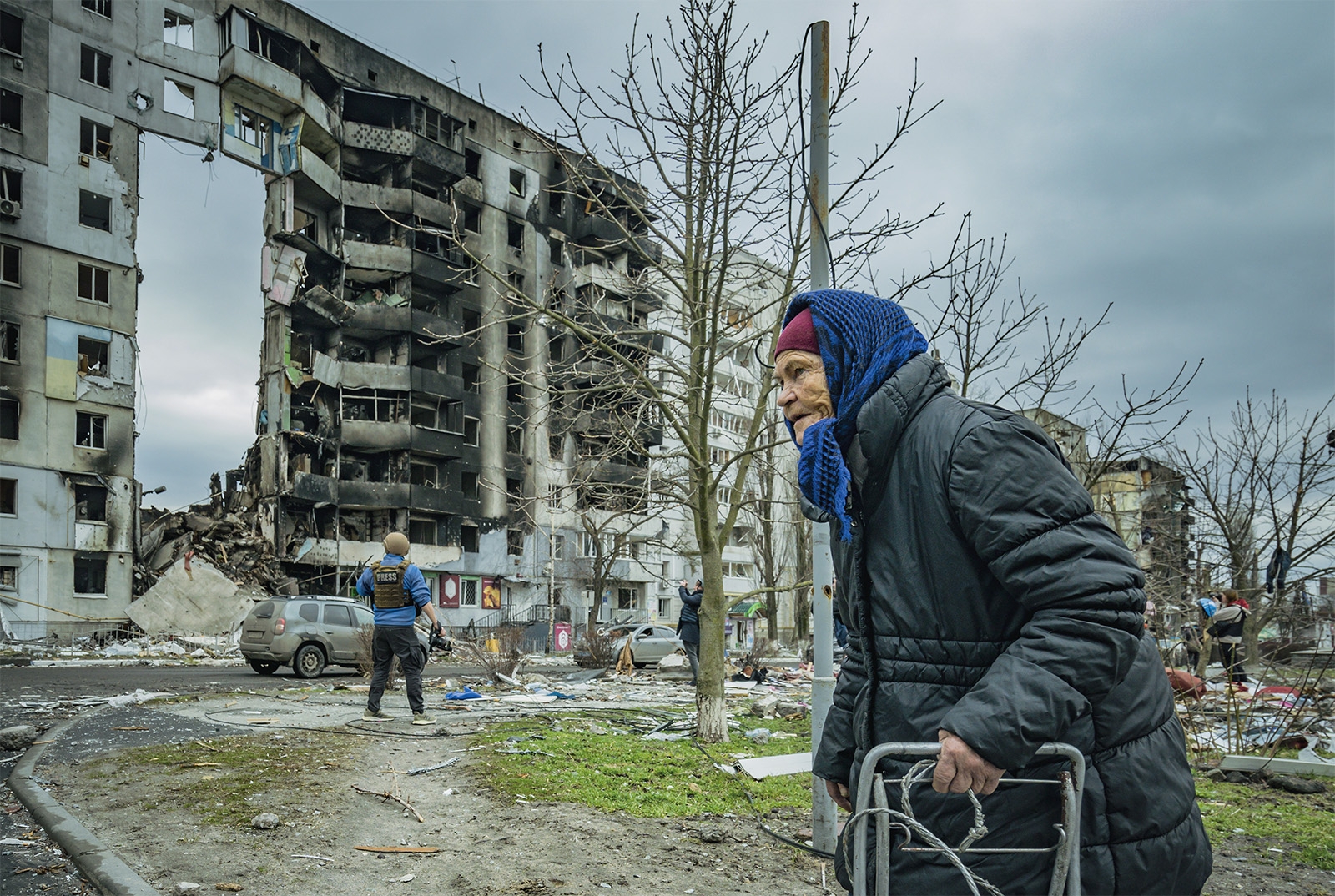  ロシア軍とウクライナ軍の戦闘で破壊された建物の前を歩く住民。首都キーウ（キエフ）郊外のボロディアンカで撮影。避難民はウクライナ国内外で1000万人を超えた（写真：Celestino Arce/NurPhoto/共同通信イメージズ）