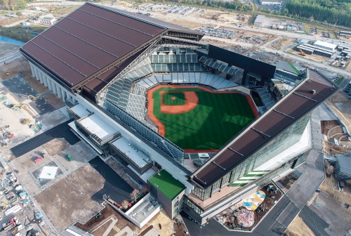 北海道北広島市に誕生した新球場「エスコンフィールド北海道」を南側上空から見る。可動屋根としての面積は世界一だ。2022年にパリーグ最下位に沈んだ北海道日本ハムファイターズの新庄剛志監督は、この新球場を本拠地として下克上を狙う。写真は22年12月竣工の前に撮影したもの（写真：大林組）