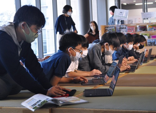 端末1人1台の環境で学ぶドルトン東京学園中等部の生徒の様子。校内はどこでも無線LANがつながる。生徒は思い思いの場所で調べ学習をしている