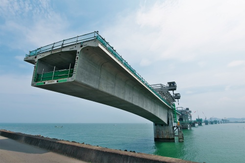 写真1■ 手前に見えるのは左岸側のP1橋脚。台船でセグメント桁を運んで、吊り上げて架設する。2020年7月20日撮影(写真:生田 将人)