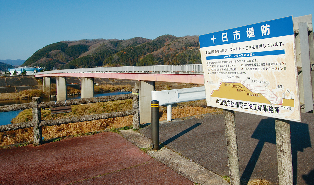 写真1■ 馬洗川では、アーマーレビー工法によって堤防を強化した旨を、簡易な図面とともに現場に掲げている（写真：日経コンストラクション）