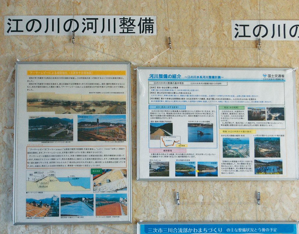 写真2■ 三次河川国道事務所に入ってすぐのロビースペースに掲げられたパネル。同事務所管内での取り組みの1つとして、馬洗川でのアーマーレビーによる堤防整備を紹介している（写真：日経コンストラクション）