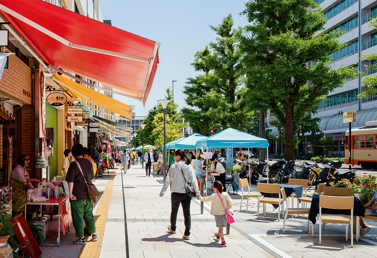 写真2■ 歩道に面する店舗の前に、商店街組合が「景観まちづくりデザインガイドライン」で規定したカラフルな可動式のオーニングテントが並ぶ（写真：山内紀人）