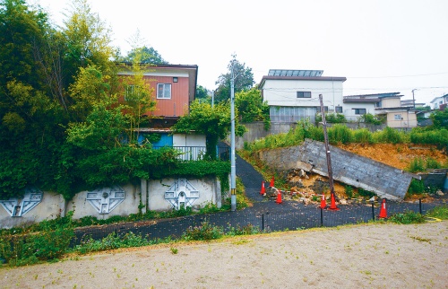 資料3■ 仙台市太白区緑ケ丘4丁目付近であった擁壁崩れ。隣に見えるのは2011年の東日本大震災で被災し、アンカーで対策を講じていた擁壁。今回の地震では無被害だった（写真：日経クロステック）