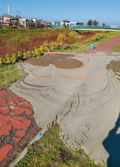 資料1■ 札樽トンネルの上部を通る「中の川」の堤防上で漏出した泥土。泥土の大部分は気泡材なので流動性が高い。2022年11月2日午前11時50分ごろ撮影(写真:鉄道建設・運輸施設整備支援機構)