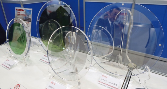 図1 マルエム商会のブースに出展されたJSGの12インチSiCウエハー(左奥と右)。左奥はN型、右は光学用(写真:日経クロステック)