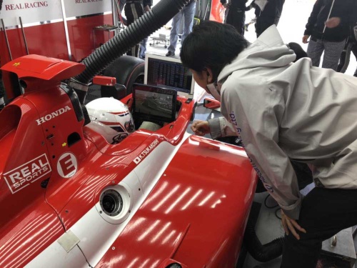 2018年の「全日本スーパーフォーミュラ選手権」のピットで、アビームコンサルティングのスタッフがドライバーの塚越広大選手にデータ解析結果を伝える様子。走行中は音声で伝える必要がある