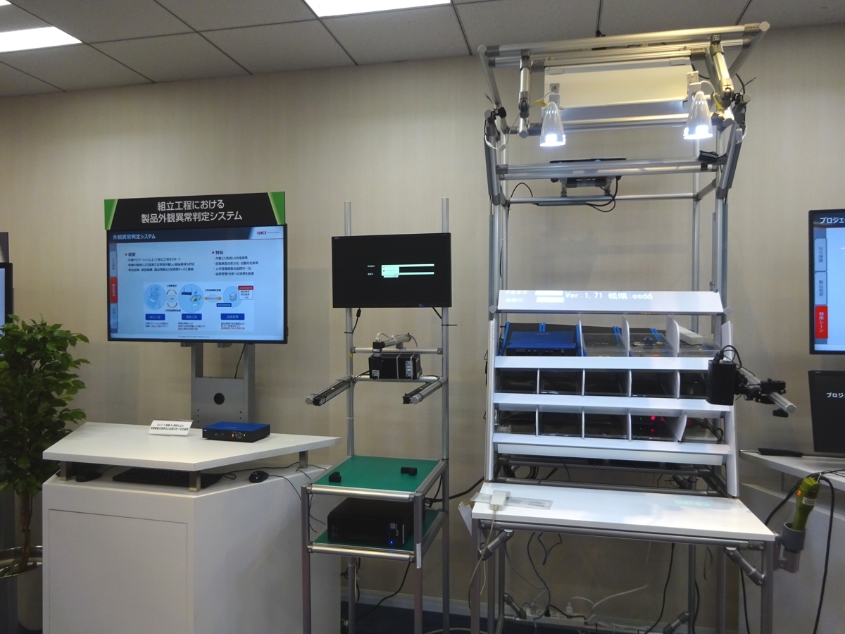 図1　OKIのショールームにある「プロジェクションアッセンブリーシステム」の展示 富岡工場の製品組み立て工程支援が出発点だったシステム。（写真：日経クロステック）